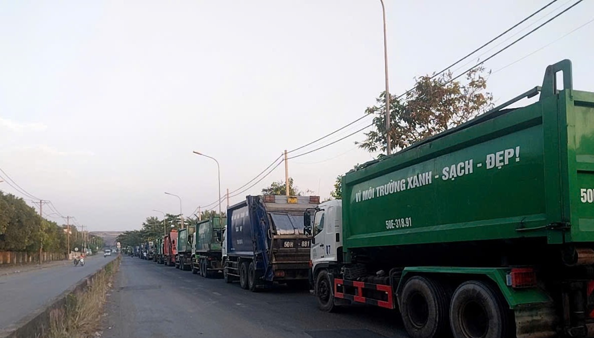 Xe rác xếp hàng dài chờ tới 18h để vào bãi rác Đa Phước.  Ảnh: Minh Tâm