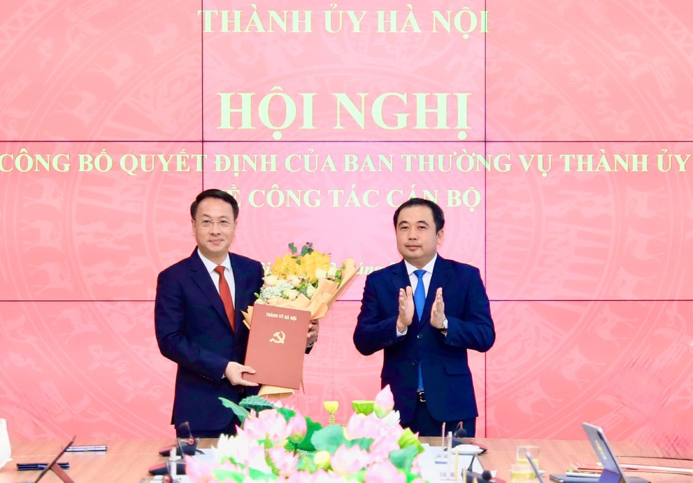 Politburo member, Hanoi Party Secretary Tran Duc Thang presents the decision and flowers to congratulate Mr. Tran Dinh Canh. Photo Quang Thai