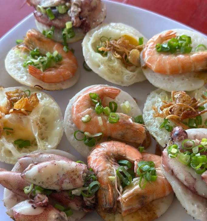 Một đĩa bánh căn thập cẩm nhân mực, tôm, trứng.
