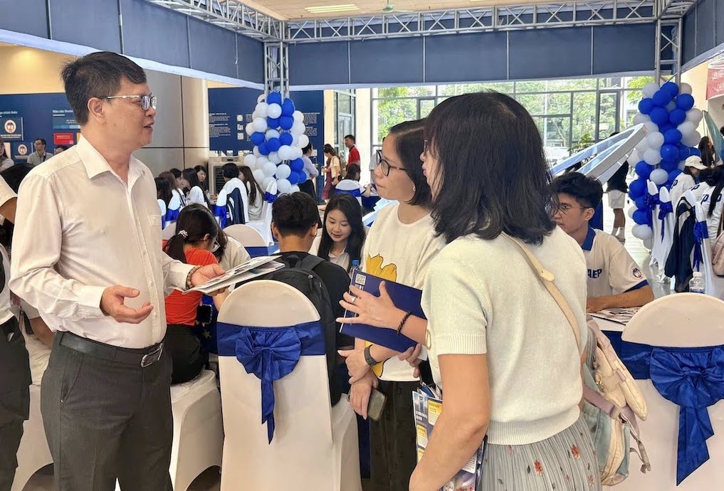 TS. Vũ Văn Ngọc - Viện trưởng Viện Đào tạo Tiên tiến, Chất lượng cao & POHE, Đại học Kinh tế Quốc dân trao đổi với phụ huynh, học sinh tại ngày hội tư vấn, hướng nghiệp năm 2026. Ảnh: Vân Trang