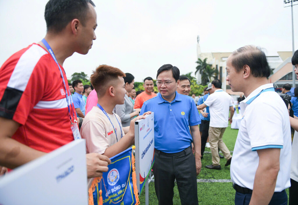 Ông Nguyễn Anh Tuấn - Ủy viên Ban Chấp hành Trung ương Đảng, Phó Chủ tịch Ủy ban Trung ương Mặt trận Tổ quốc Việt Nam, Chủ tịch Tổng Liên đoàn Lao động Việt Nam (giữa ảnh) trao cờ lưu niệm cho Ban tổ chức giải đấu. Ảnh: Danh Khang
