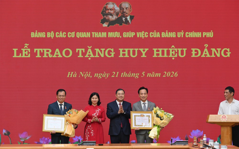 Politburo Member, Standing Deputy Secretary of the Government Party Committee, Standing Deputy Prime Minister Pham Gia Tuc and Member of the Party Central Committee, Deputy Secretary of the Government Party Committee, Secretary of the Party Committee of advisory and assisting agencies of the Government Party Committee Nguyen Thi Tuyen - awarded the 35-year Party Badge and presented flowers to congratulate 2 party members, Mr. Lai Xuan Lam (right) and Mr. Chu Dinh Dong. Photo: VGP