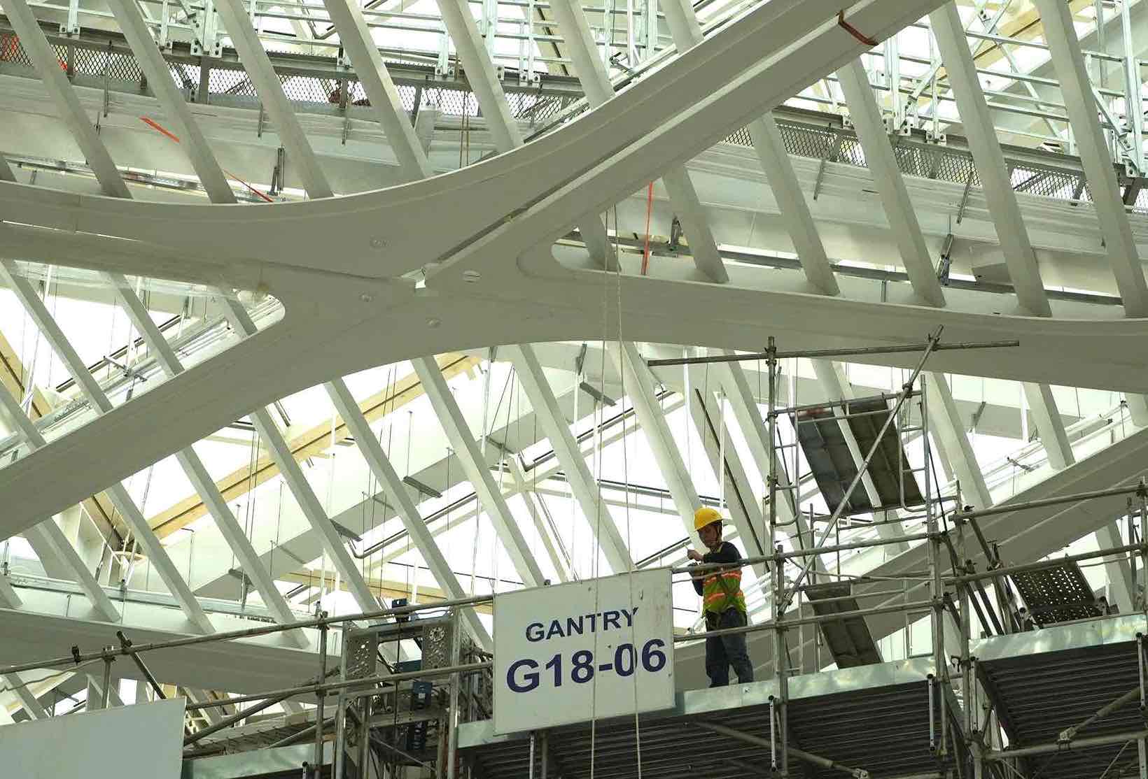 Liên danh nhà thầu đang tiếp tục thi công hoàn thiện trần áp mái dưới lớp mái Skylight ở mái trung tâm nhà ga hành khách sân bay. Ảnh: HAC