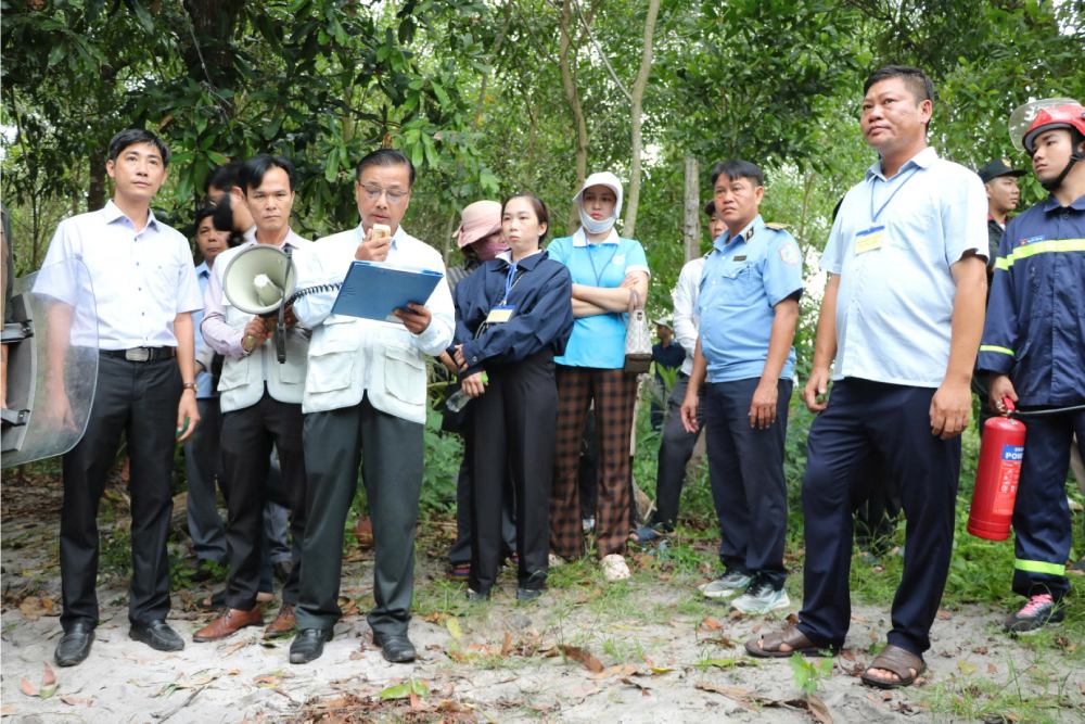 Lực lượng chức năng đọc các quyết định cưỡng chế, thu hồi đất. Ảnh: Tiến Dũng