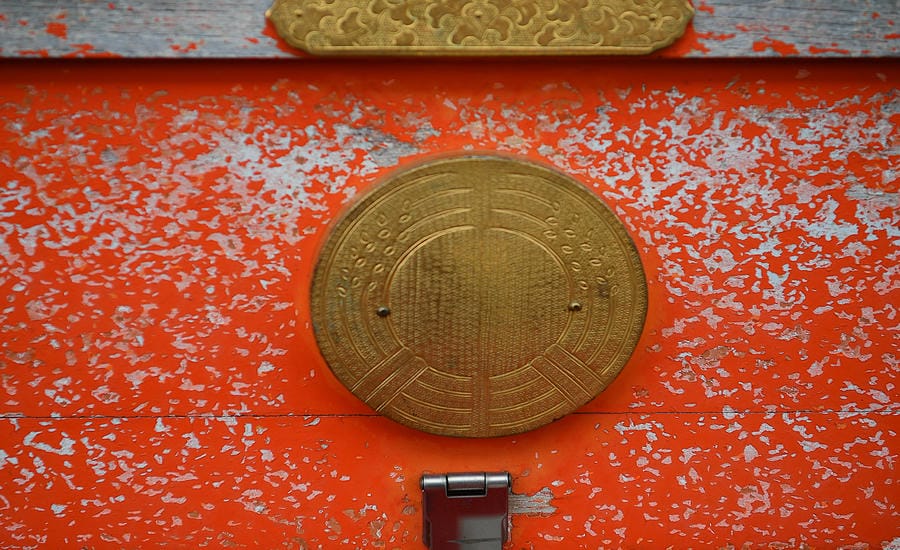 Lớp sơn đỏ bong tróc theo thời gian trên một phần kiến trúc tại Fushimi Inari Taisha. Ảnh: Việt Văn