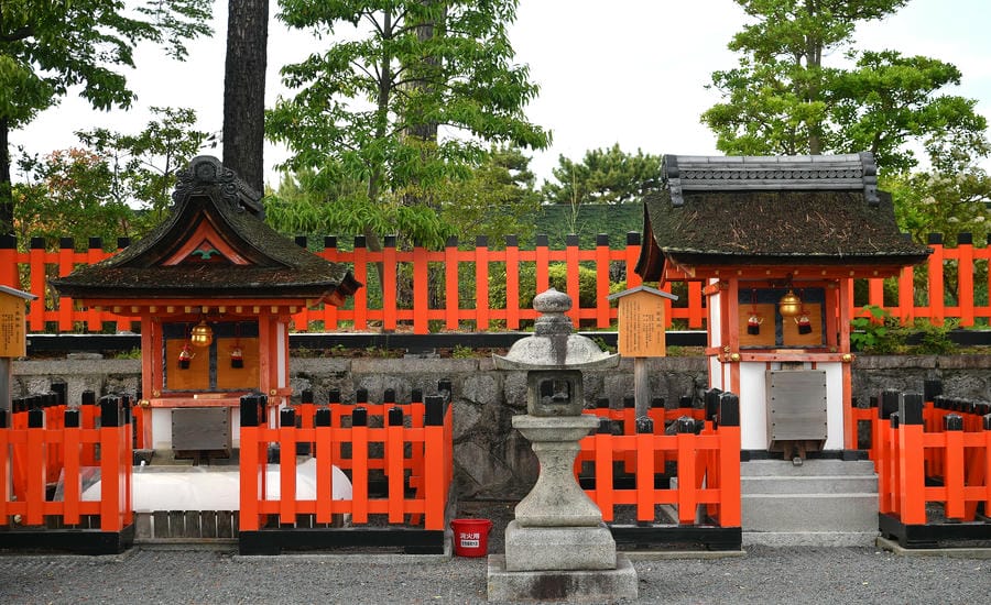 Hai đền thờ nhỏ nằm lặng phía sau những hàng rào đỏ son tại Fushimi Inari Taisha. Ở Kyoto, ngay cả những không gian tín ngưỡng nhỏ bé nhất cũng được gìn giữ với sự chăm chút gần như tuyệt đối. Ảnh: Việt Văn