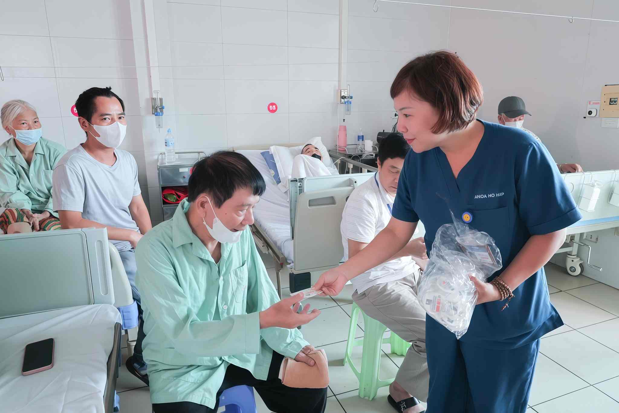 Người bệnh và người nhà được bác sĩ phát tờ rơi, trao móc khóa tuyên truyền về tác hại của thuốc lá. Ảnh: BVCC