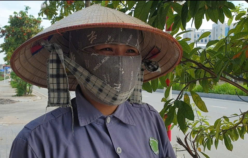 Bà Ngô Thị Luyến, 61 tuổi dọn vệ sinh dưới thời tiết nắng gắt. Ảnh: Quang Minh.
