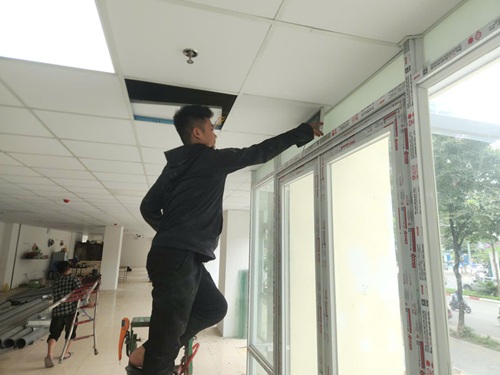 Công nhân lắp đặt biển chỉ dẫn, PCCC, thoát hiểm của toà nhà. Ảnh: Minh Hạnh