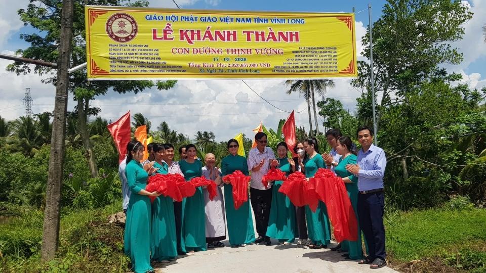 Lãnh đạo địa phương, đại diện Phật giáo Vĩnh Long, đơn vị tài trợ và người dân thực hiện nghi thức cắt băng khánh thành tuyến đường giao thông nông thôn, góp phần hoàn thiện hạ tầng, thuận lợi đi lại và phát triển kinh tế địa phương. Ảnh: Hoàng Lộc