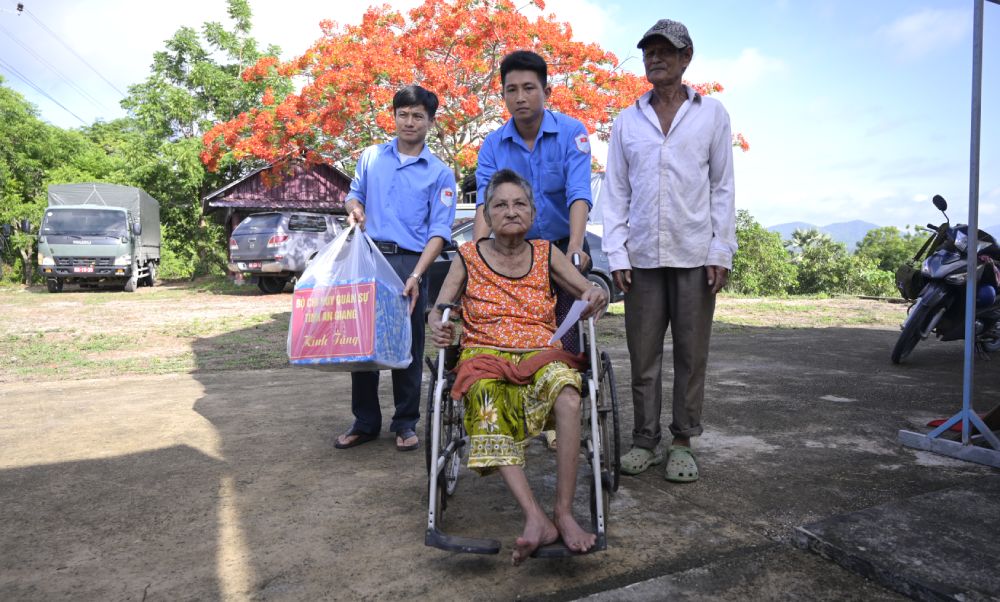 Cán bộ, chiến sĩ Đội K93 hỗ trợ người dân nhận quà, khám bệnh. Ảnh: Phương Vũ