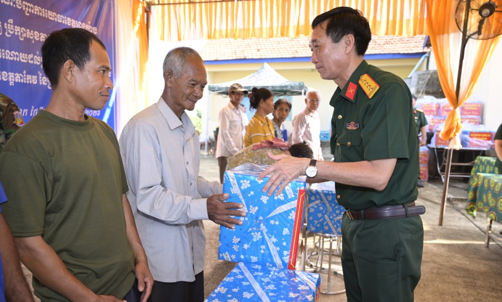Đại tá Cao Minh Tâm, Phó Chính ủy Bộ CHQS tỉnh An Giang tặng quà cho người dân tỉnh Tà Keo, Vương quốc Campuchia. Ảnh: Phương Vũ