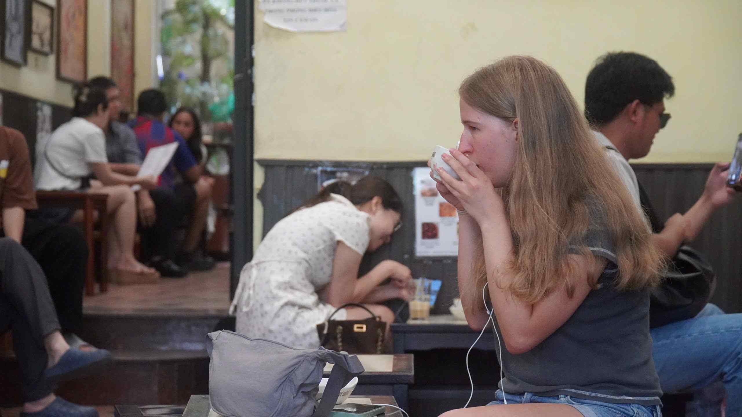 Du khách Tây trải nghiệm cà phê trứng tại quán. Ảnh: Minh Vũ