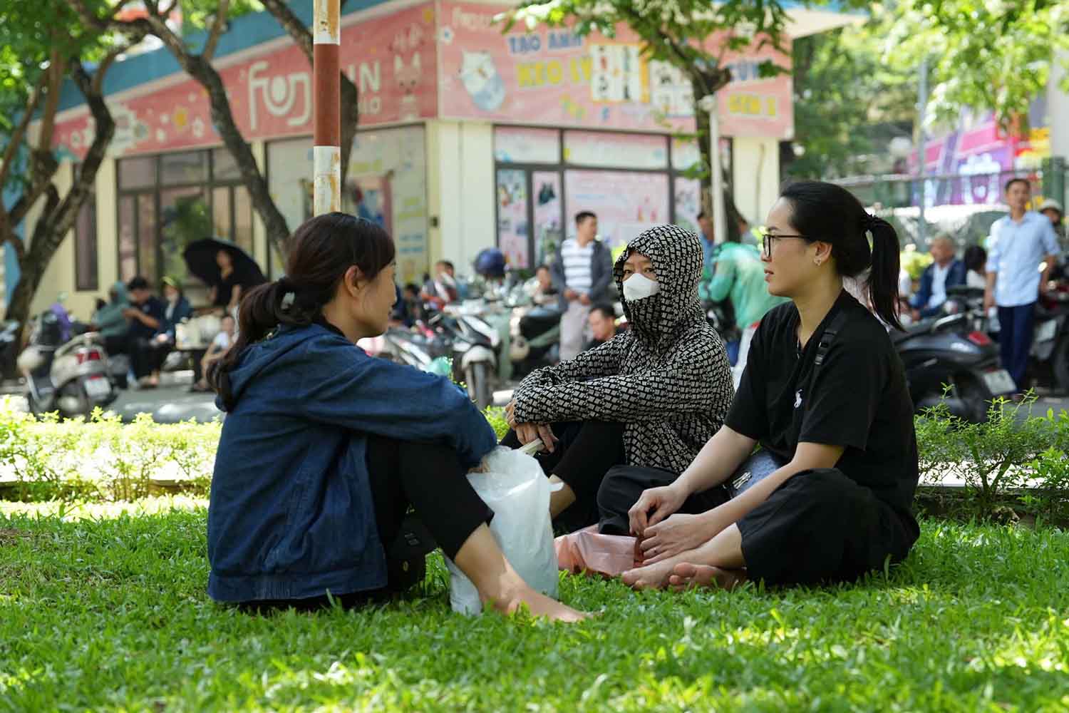 Nhiều phụ huynh ngồi dưới tán cây chờ sĩ tử hoàn thành bài thi đánh giá năng lực. Ảnh: Sóng Hữu