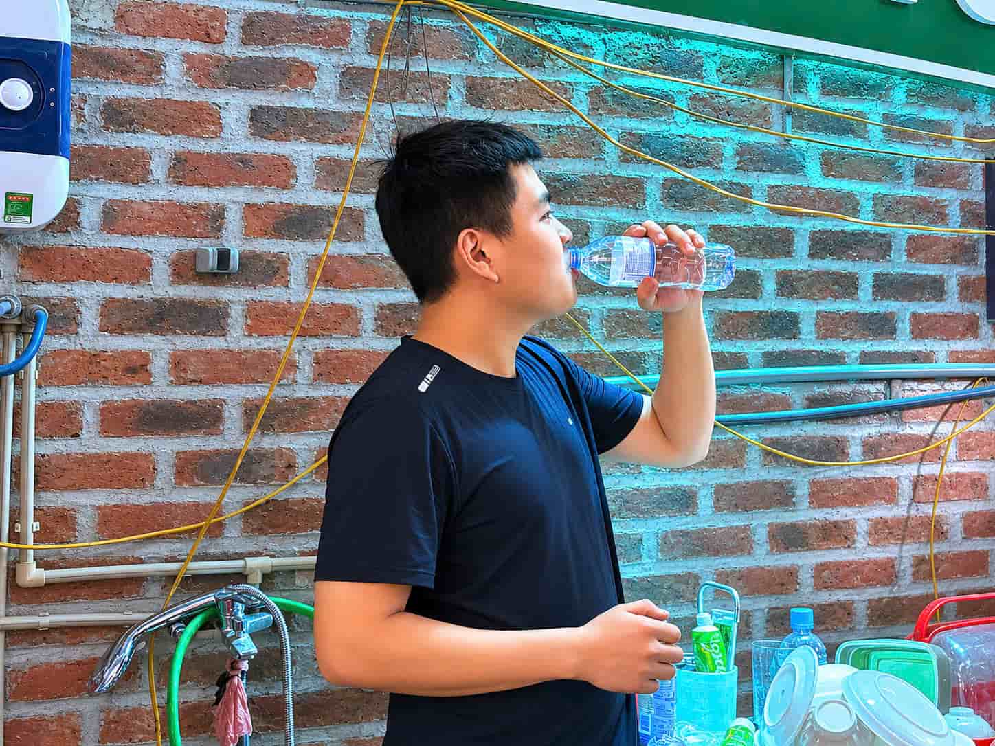 Nắng nóng gay gắt khiến anh Đại liên tục bổ sung nước giữ sức. Ảnh: Huyền Trang