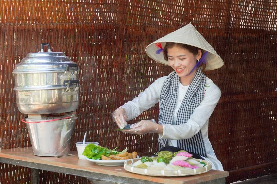 Chị Yến Phương trải nghiệm làm bánh dân gian. Ảnh: Tạ Quang