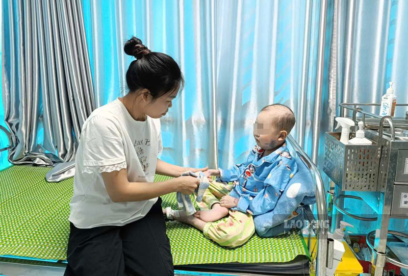 Ms. Hong takes care of her son at Thai Binh Children's Hospital, Hung Yen province. Photo: Luong Ha