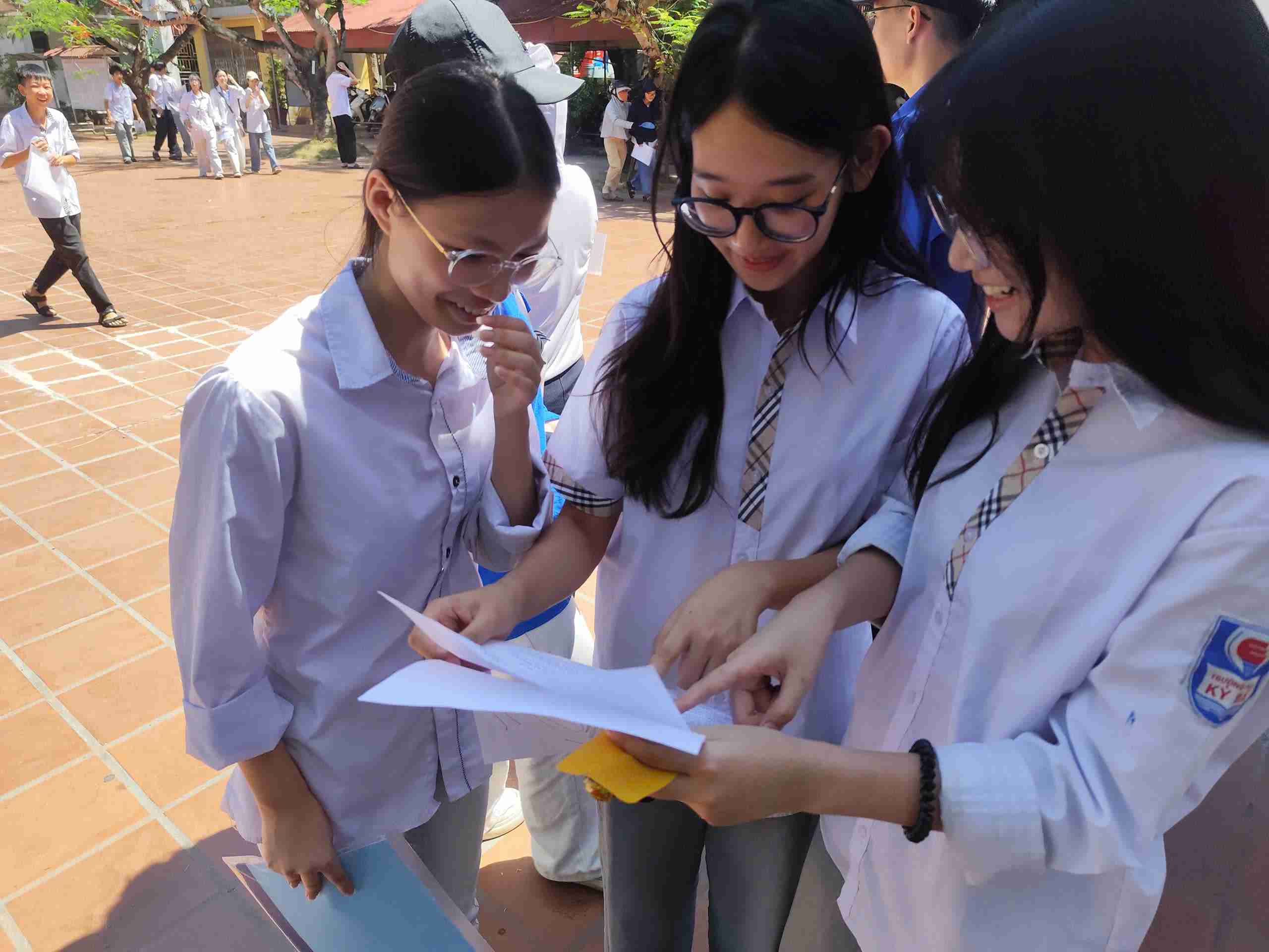 Candidates exchange papers after finishing the Literature exam of the 10th grade entrance exam. Photo: Hai Minh