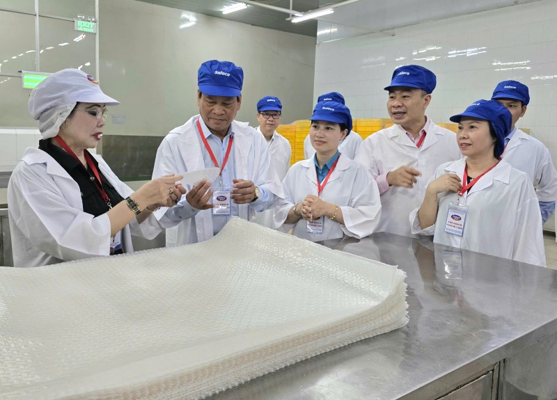 Bà Phạm Thị Thu Hồng - Tổng giám đốc Safoco (bìa trái) - giới thiệu sản phẩm bánh tráng của Safoco với Phó Chủ tịch Tổng LĐLĐ Việt Nam Huỳnh Thanh Xuân. Ảnh: Nam Dương
