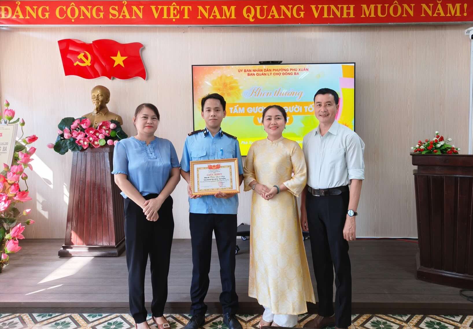 Dong Ba market management board presents certificates of merit to security guards who picked up lost items and returned them to the losers. Photo: Huynh Long