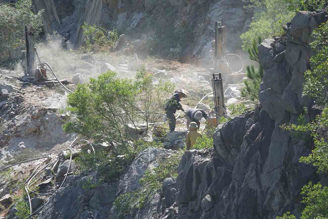 Potential safety hazards when workers drilling for blasting to mine stone at Hong Vuong quarry are still not fully equipped with labor protection. Photo: Tran Tuan