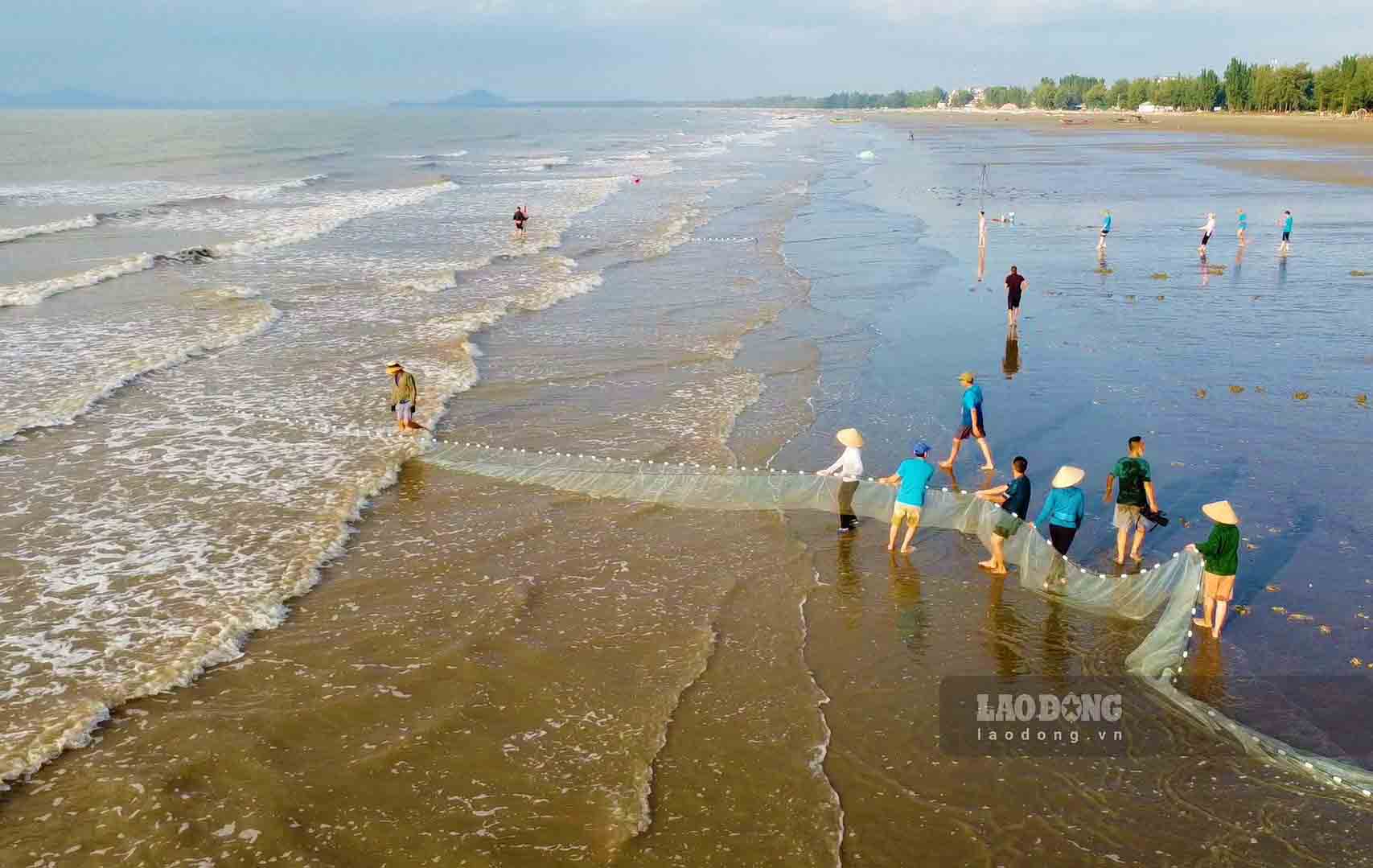Du khách tập làm ngư dân trên bãi biển Trà Cổ. Ảnh: Đoàn Hưng