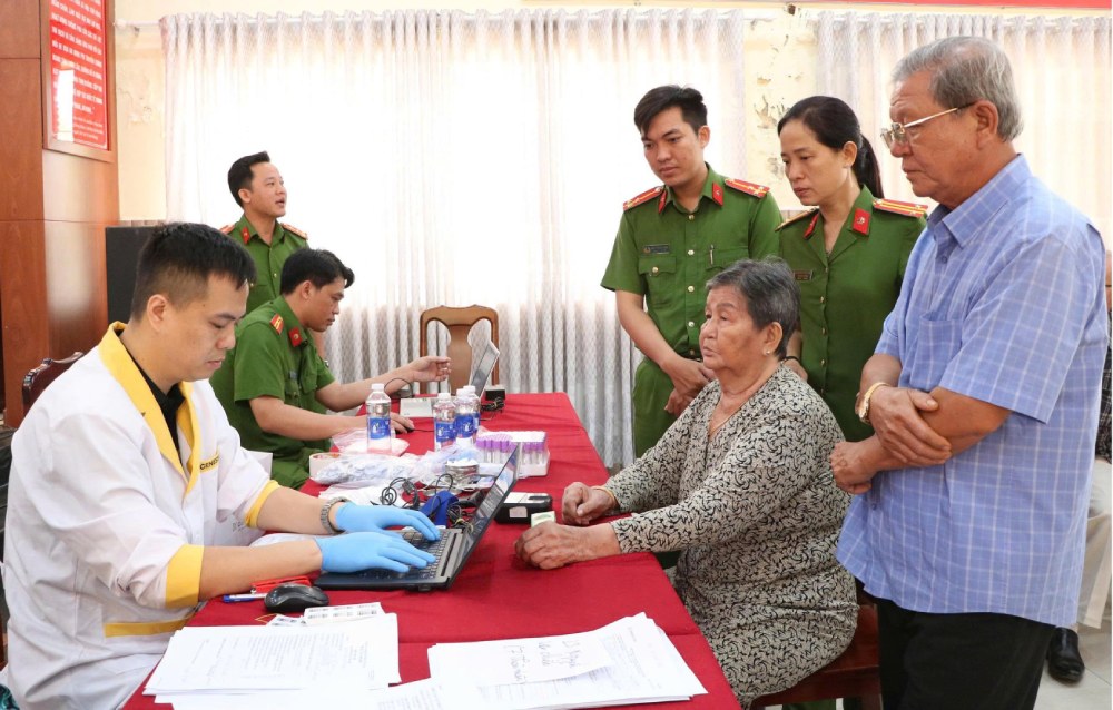 Cán bộ phòng Cảnh sát QLHC về TTXH tổ chức thu nhận mẫu AND thân nhân liệt sĩ chưa xác định danh tính. Ảnh: Tiến Dũng