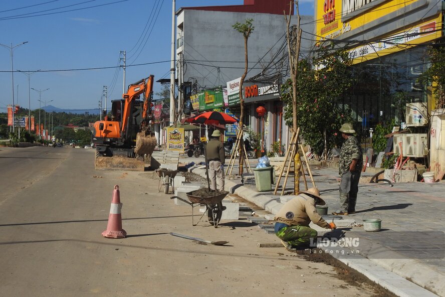 Các công nhân đang hoàn thiện vỉa hè. Ảnh: Tô Công