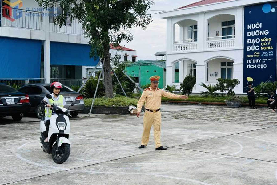 꽝닌성 공안 교통 경찰서 간부들이 쩐흥다오 고등학교(꽝닌성 마오케동) 학생들에게 안전 운전 기술을 지도하고 있습니다. 사진: 꽝닌 전자 정보 포털