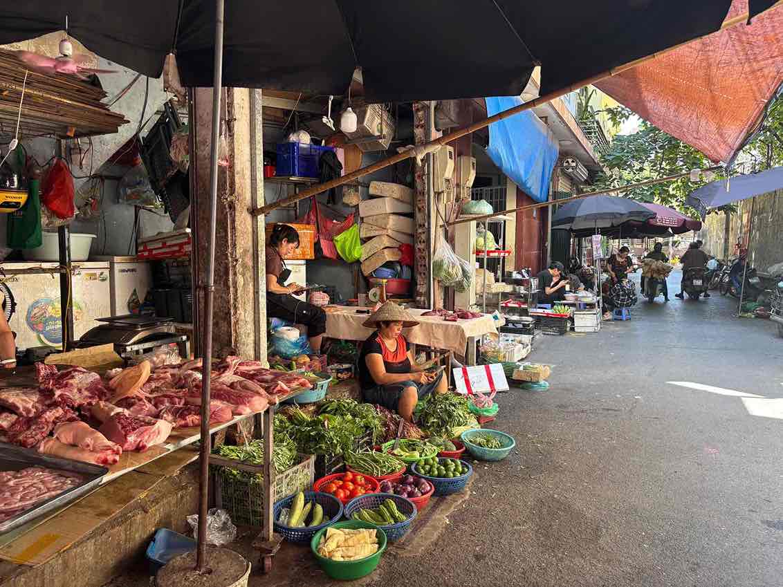 Nắng nóng kéo dài khiến nhiều mặt hàng rau xanh, thực phẩm tươi sống tại chợ Trung Hoà (Cầu Giấy) tăng giá nhẹ, trong khi tiểu thương cũng chịu thêm áp lực bảo quản hàng hóa.