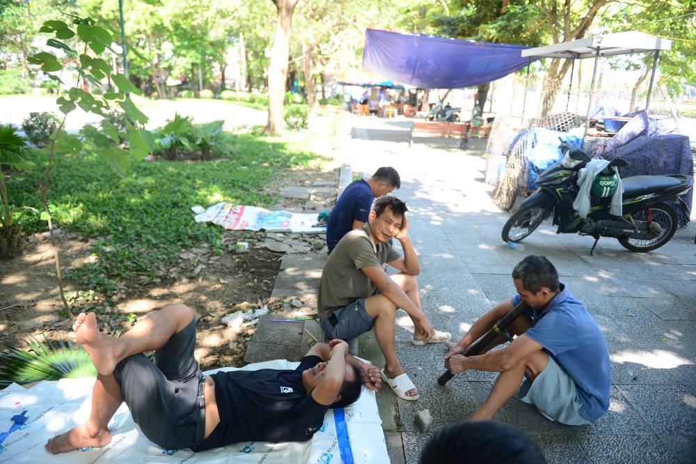 Nhiều người lao động tranh thủ tìm đến công viên để tránh nóng, nghỉ trưa. Ảnh: Quách Du