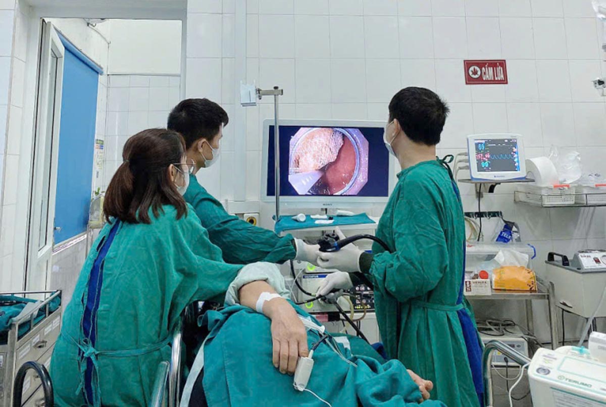 Ekip can thiệp lấy khối bã thức ăn. Ảnh: BV Bãi Cháy