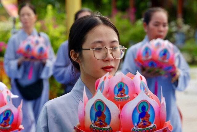 Phật tử thành kính dâng hoa sen tại khoá tu Dược Sư. Ảnh: Ban tổ chức