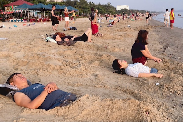 De nombreux habitants de Da Nang empilent du sable tôt le matin sur la plage de Nguyen Tat Thanh. Photo: Ngoc Oanh