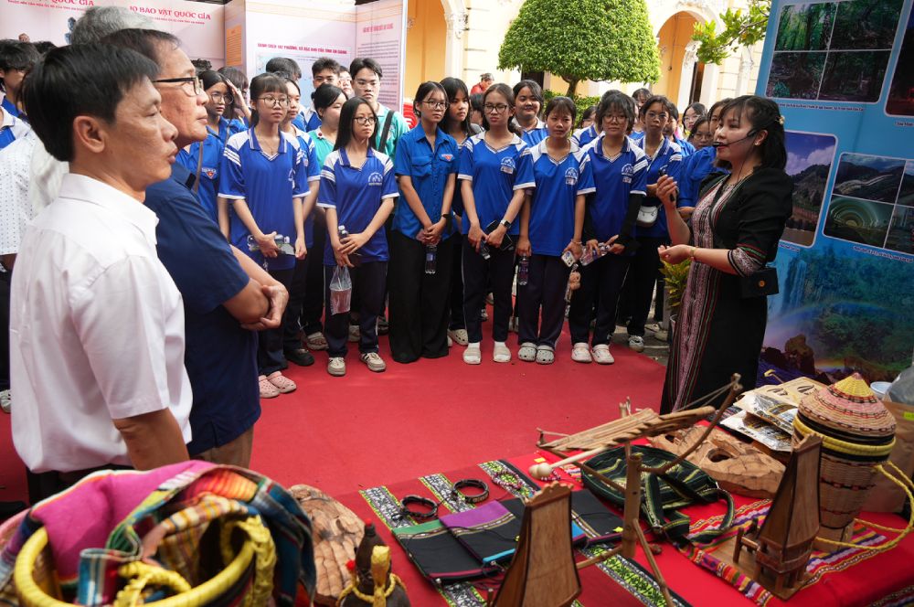 Các em học sinh tham quan, nghe giới thiệu tại triển lãm. Ảnh: Nam Phương