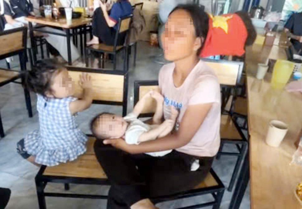 Người mẹ đưa theo 2 con nhỏ thời điểm ghé vào một quán ăn ở xã Cẩm Lạc để nghỉ ngơi. Ảnh cắt từ clip