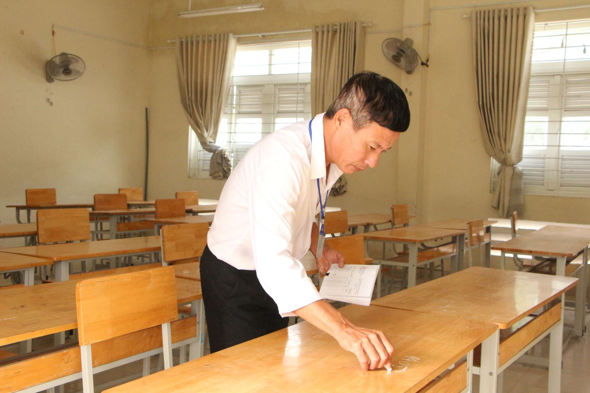 Các giám thị thực hiện đánh dấu số báo danh trước khi thí sinh vào phòng thi. Ảnh: Phương Linh