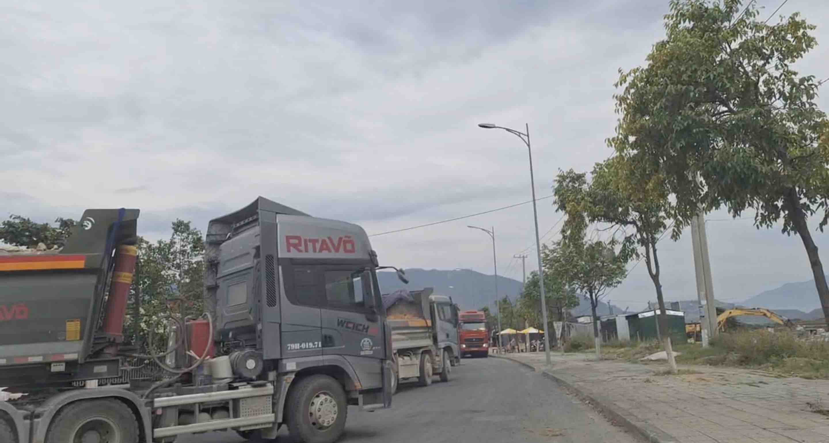 Construction vehicles carrying materials running on the road cause people to worry about pollution and traffic safety. Photo: Huu Long