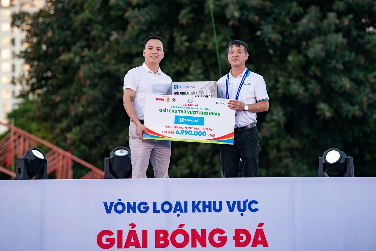 Nhà báo Nguyễn Đức Bình - Phó trưởng Văn phòng đại diện báo Tuổi Trẻ tại Hà Nội - thay cầu thủ Lò Văn Tâm nhận giải thưởng từ ông Đặng Ngọc Phúc - Giám đốc Công ty TNHH TAPUHO Việt Nam. Ảnh: TAPUHO Việt Nam 