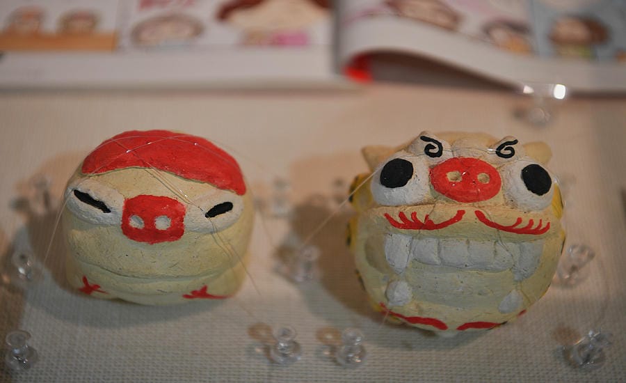 Tượng Shisa (linh vật sư tử - chó canh giữ của Okinawa) xuất hiện trong tập truyện kể về chuyến du lịch Okinawa của Saori Oguri và chồng bà là Tony László, khi họ cùng trải nghiệm hoạt động tự tay làm tượng Shisa. Tượng bên phải do Saori Oguri làm, còn tượng bên trái do Tony làm. Ảnh: Việt Văn