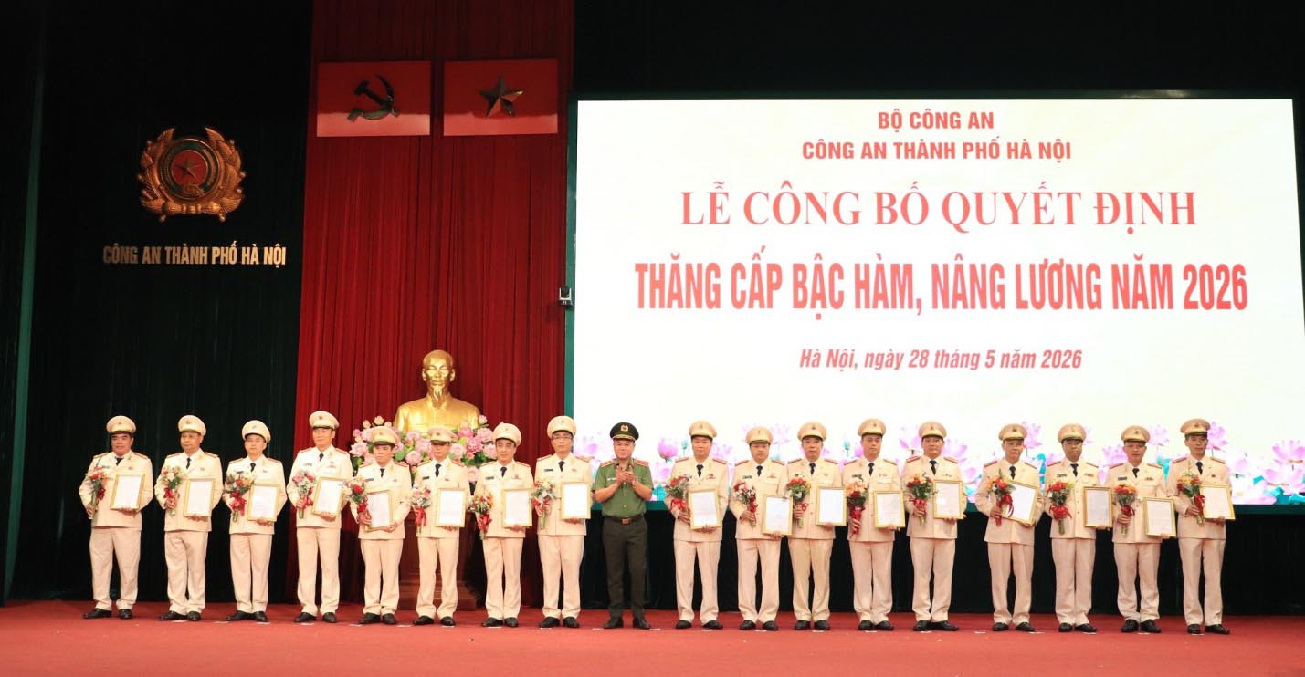 Lieutenant General Nguyen Thanh Tung, Director of Hanoi City Police, presents decisions and flowers to congratulate comrades who have been promoted to ranks and increased salaries. Photo: Hanoi Police