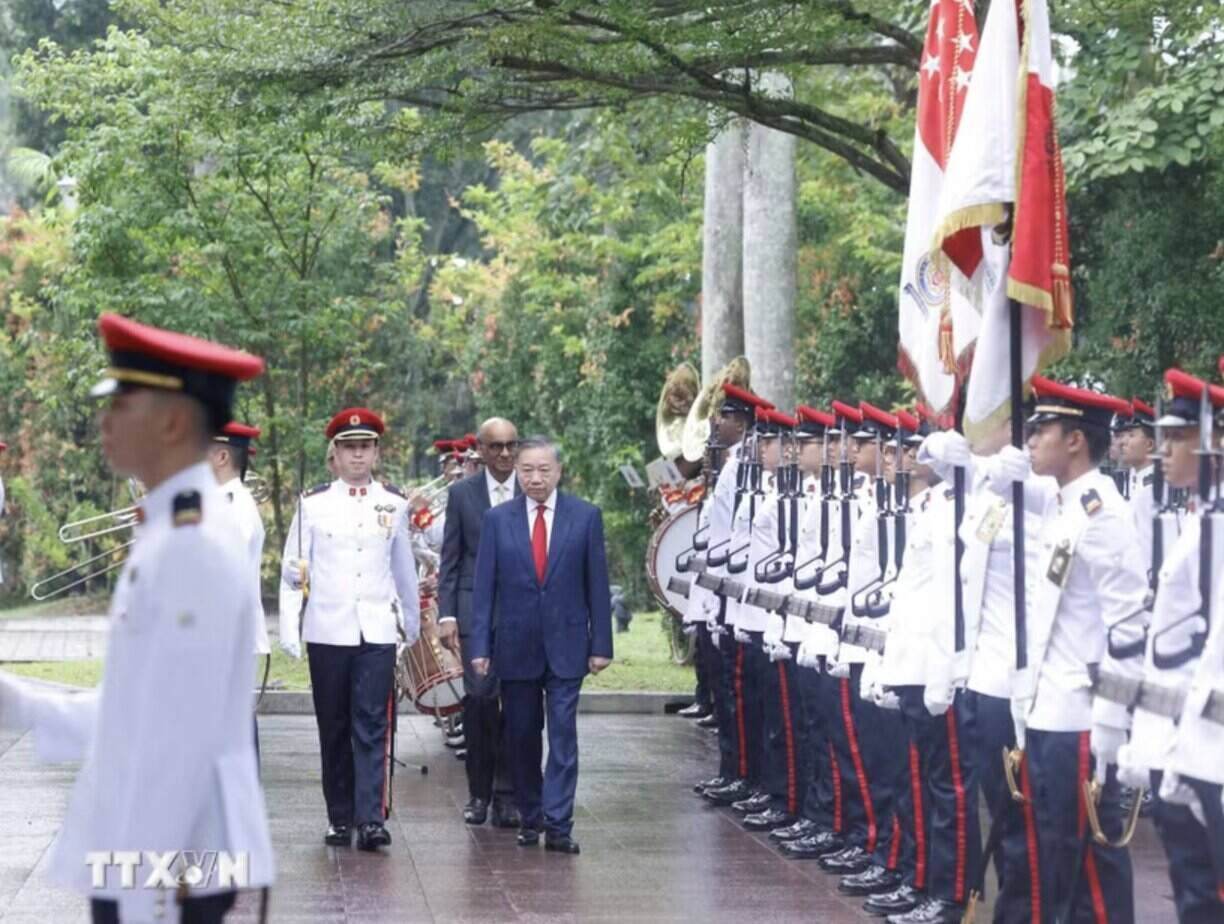 Le secrétaire général et président de la République Tô Lâm et le président singapourien Tharman Shanmugaratnam passent en revue la garde d'honneur. Photo: TTXVN