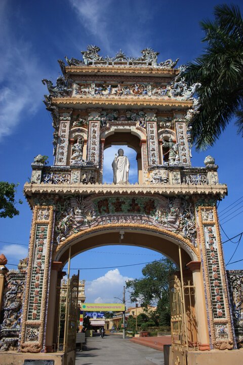 Cổng tam quan với nghệ thuật ghép mảnh sành, sứ họa lại nhiều bức tranh minh họa sự tích nhà Phật, truyện dân gian, hay mô tả tứ linh, tứ quý, hoa lá, vân vũ... Ảnh: Duy Khang