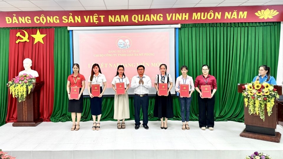 Representatives of the Party Cell of My Phong Leather and Footwear Company Limited present the decision to admit new party members to outstanding workers. Photo: Hoang Loc