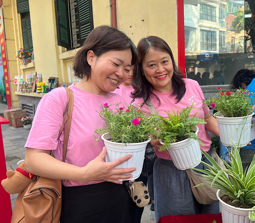 Niềm vui khi đổi rác thải lấy chậu hoa. Ảnh: Kiều Vũ 