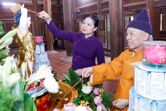  Bà Hà Thị Nga, Ủy viên Trung ương Đảng, Phó Chủ tịch - Tổng Thư ký Ủy ban Trung ương MTTQ Việt Nam  thực hiện nghi lễ tắm Phật. Ảnh: Quang Vinh
