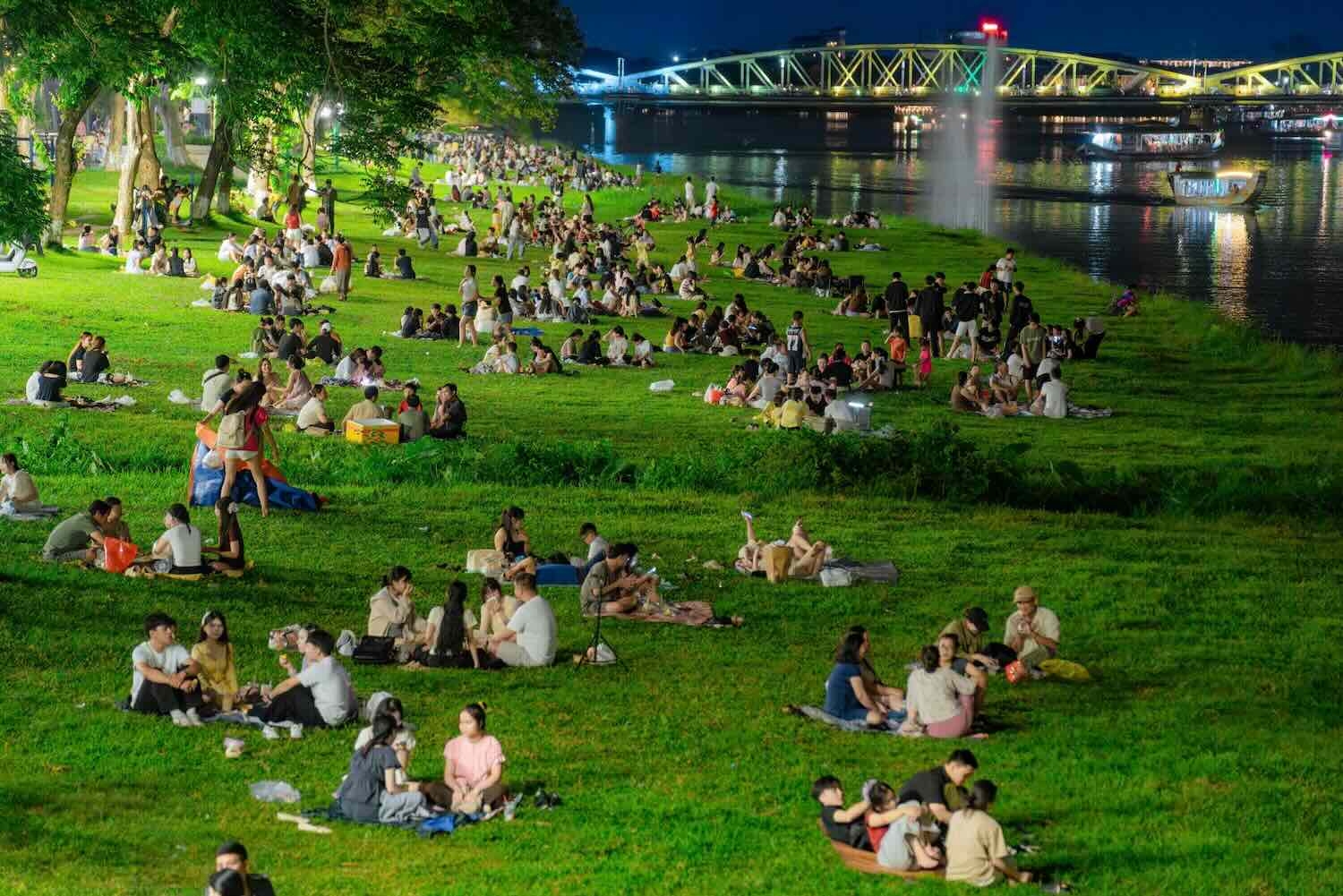 People and tourists experience fresh air on the poetic Perfume River bank. Photo: Le Dinh Hoang.
