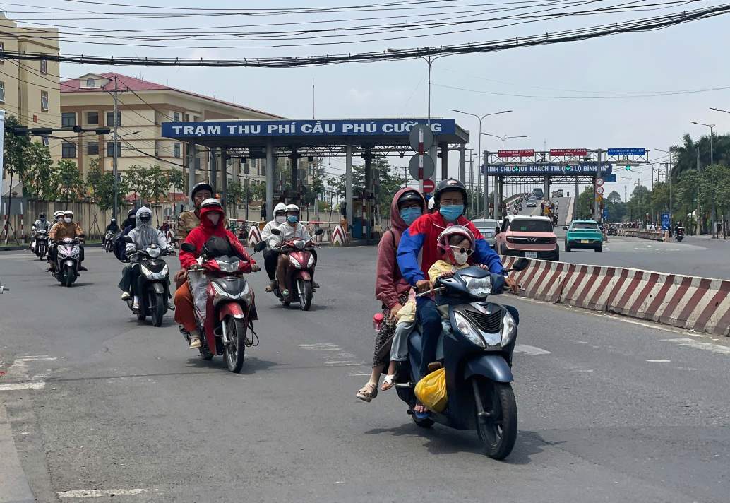 Người lao động di chuyển bằng xe máy qua cầu Phú Cường. Ảnh: Đình Trọng