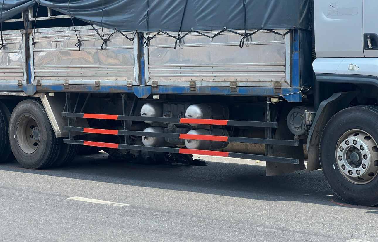 Xe máy bị cuốn vào gầm xe tải. Ảnh: Đình Trọng