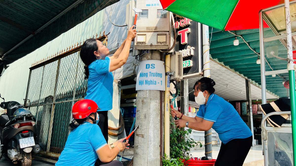 Ghi nhận người dân cùng lực lượng chức năng phường Bình Cơ tham gia bóc dỡ quảng cáo sai quy định. Ảnh: Mạnh Linh